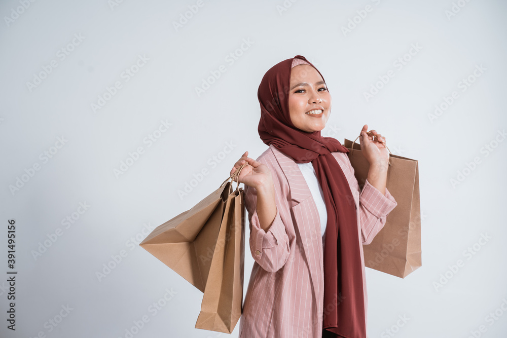 Happy business muslim woman portrait brings paper bags on white background