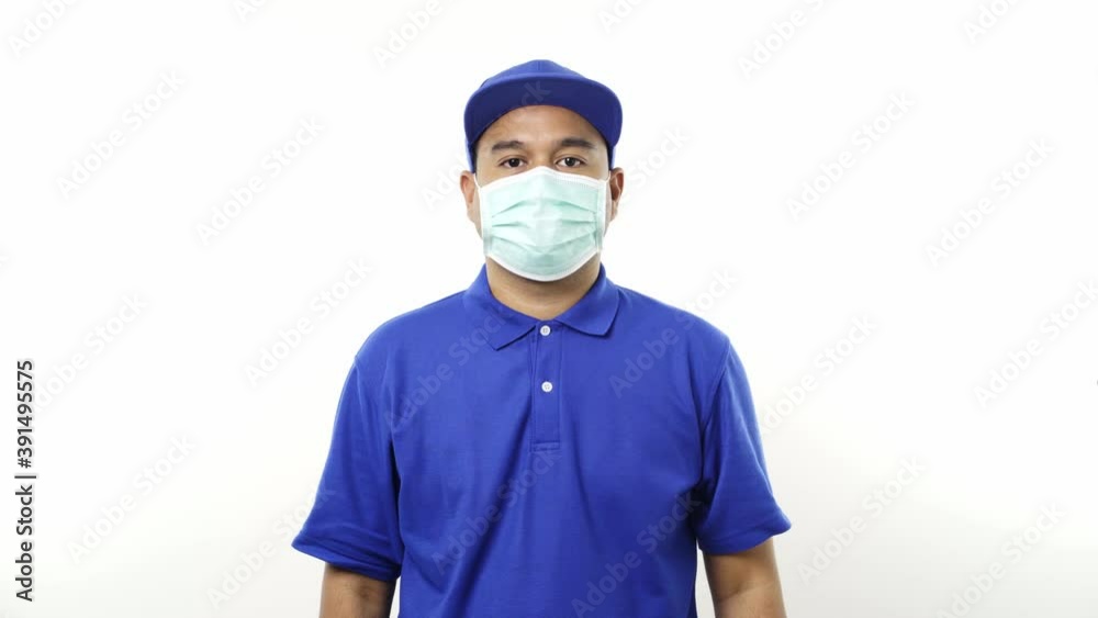 Asian delivery man in blue uniform wearing protection mask and medical rubber gloves standing on isolated white background. 4k Resolution. Asian delivery man in blue uniform wearing protection mask and medical rubber gloves standing on isolated white background. 4k Resolution.