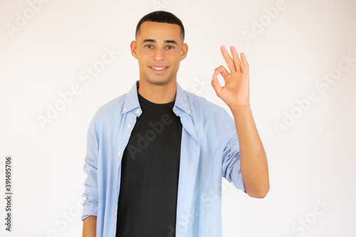 Portrait of a happy man showing okay gesture over white background