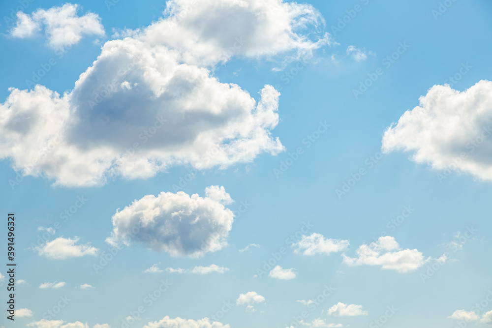 Fototapeta premium Blue sky background with white fluffy clouds in the fresh sunny day.
