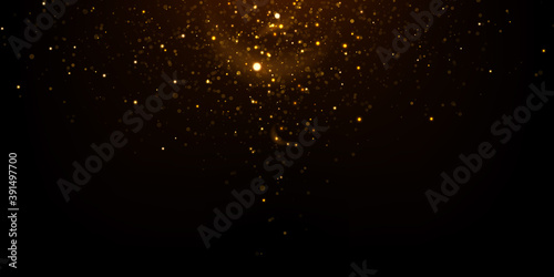 Abstract luxury background. Glowing golden particles on black. Sparkling glitter lights texture. 	