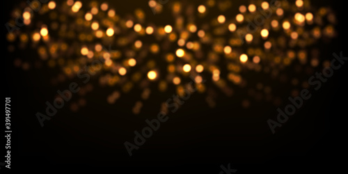 Vector golden glitter lights on black. Abstract luxury background with defocused glitters.  Festive backdrop with glowing particles.