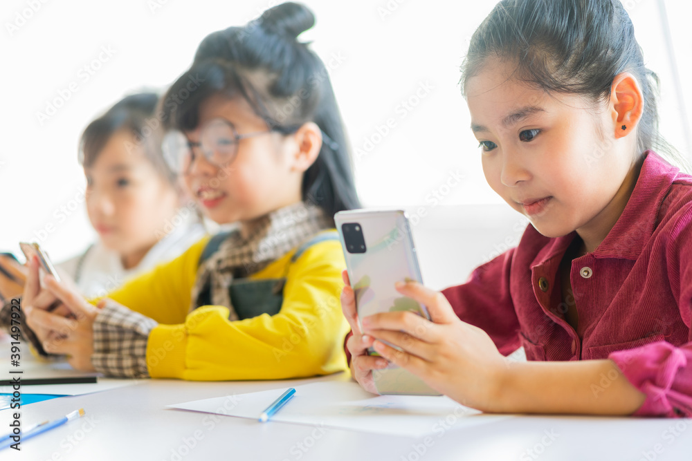 The three girls are attentively using the phone
The three girls are attentively using the phone
