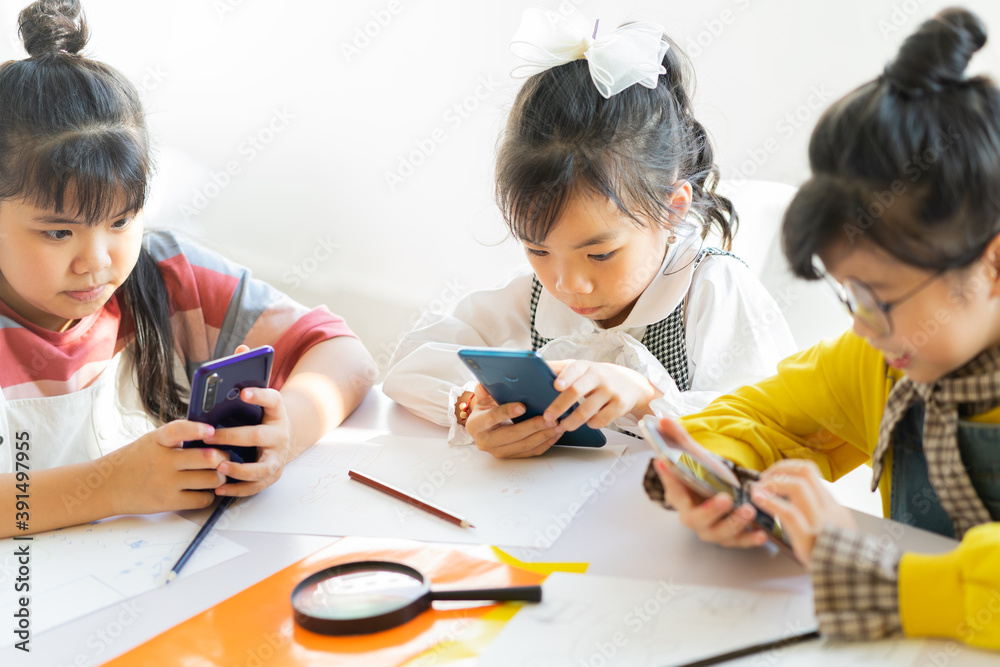 The three girls are attentively using the phone
The three girls are attentively using the phone