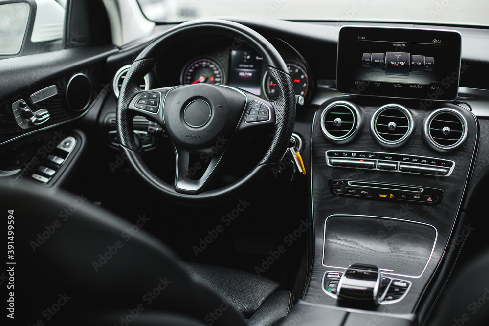 Interior view of car, luxury car steering wheel and dashboard with display or monitor screen.