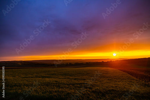 landscape with a sunset over an agricultural field in the autumn