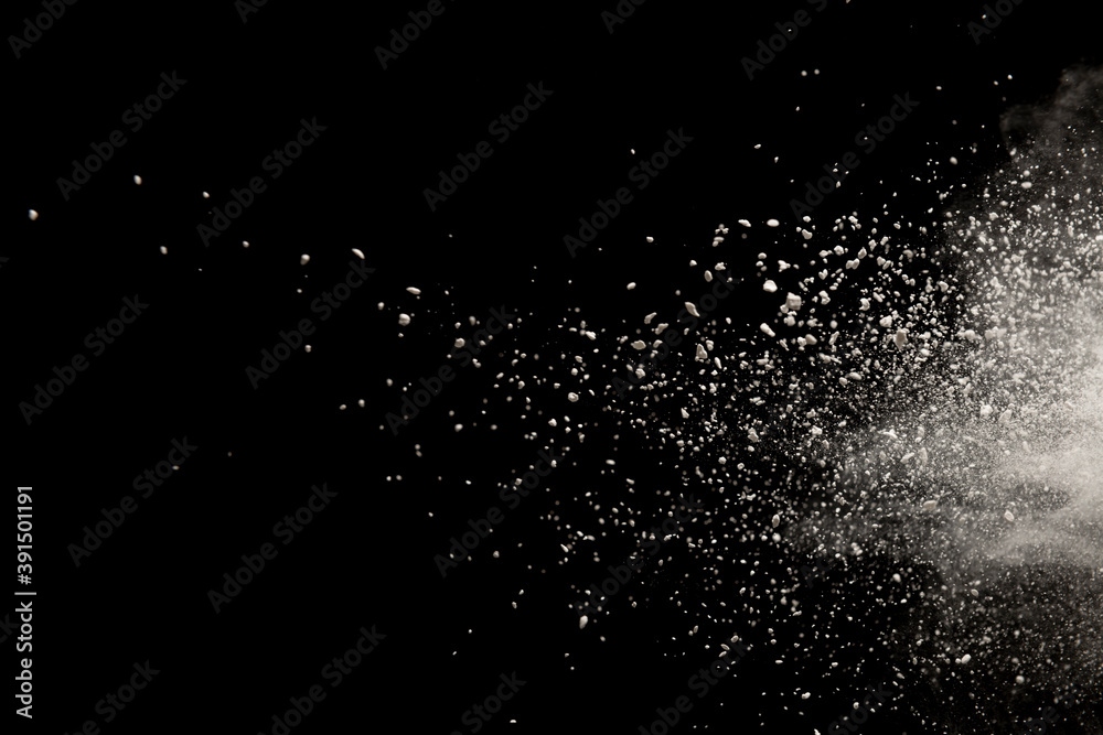 Freeze motion of white color powder exploding on black  background.