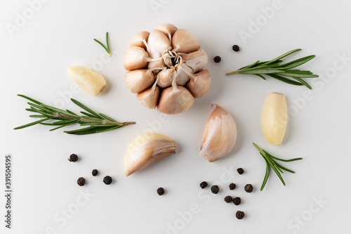 Garnish and food ingredients Black pepper Rosemary Garlic cloves and pieces of raw garlic on isolated white background. Top view Garlic bulbs.