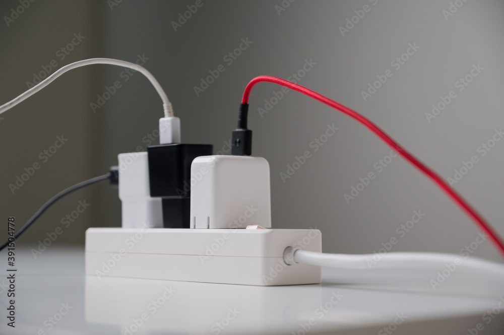 Electric adapter smartphone plug in multiple socket. Electrical equipment, electrical wires and power strips in the house. Earth Hour saving electrical energy. Electric adapter smartphone plug in multiple socket. Electrical equipment, electrical wires and power strips in the house. Earth Hour saving electrical energy.