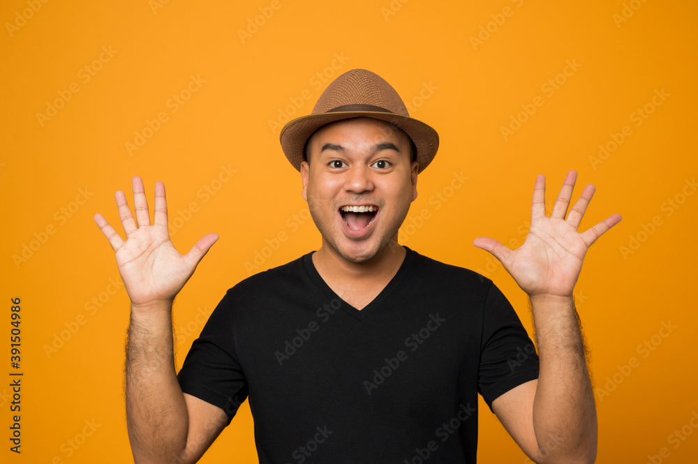 Handsome man in hat wearing casual clothes showing two palms, giving high five gesture isolated on yellow background.