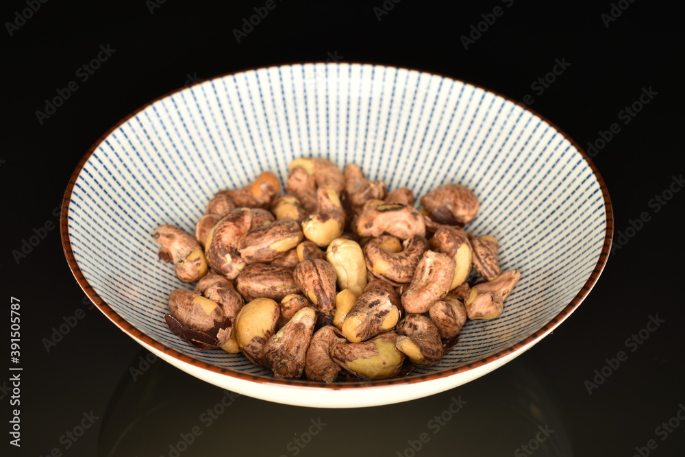 Fragrant roasted cashews, close-up, on a black background. Fragrant roasted cashews, close-up, on a black background.
