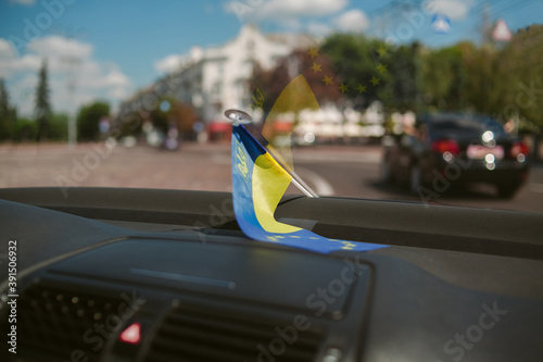 Flag of European Union and Ukraine inside the car. Flags of European Union and Ukraine together rendering union and cooperation. National symbol attributes of Ukraine and the European Union.