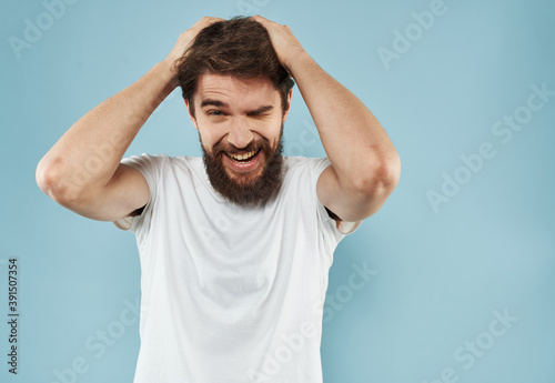 Handsome man with beard on blue background white t-shirt portrait cropped view