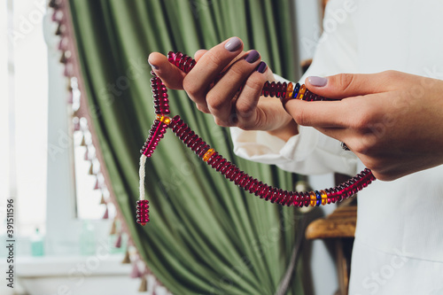 Fotografia Religious Asian buddhist woman praying with hand holding rosary beads