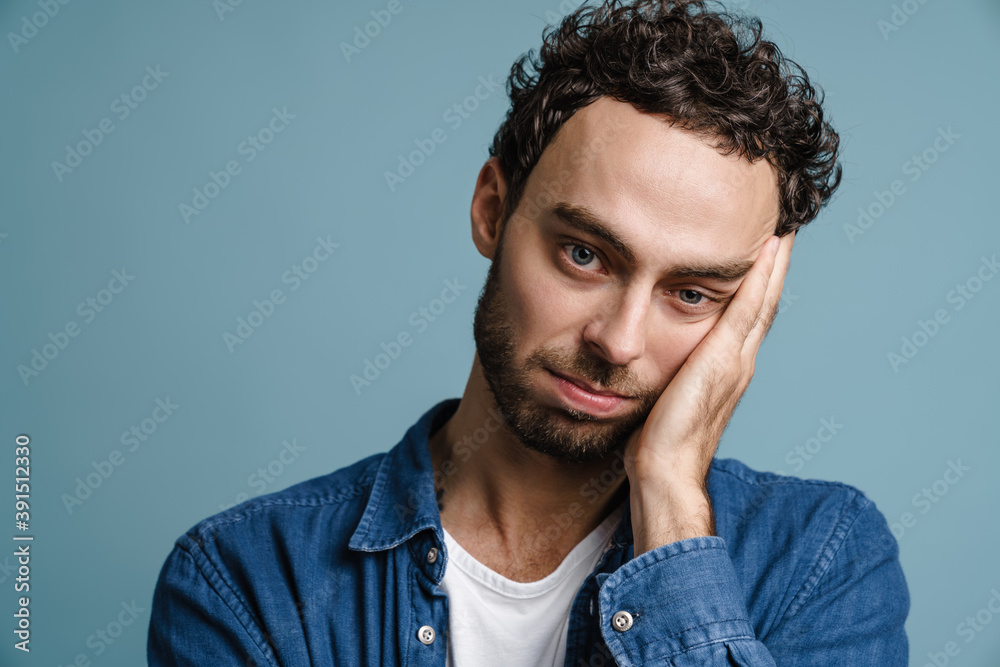 Obraz premium Tired unshaven handsome guy posing and looking at camera