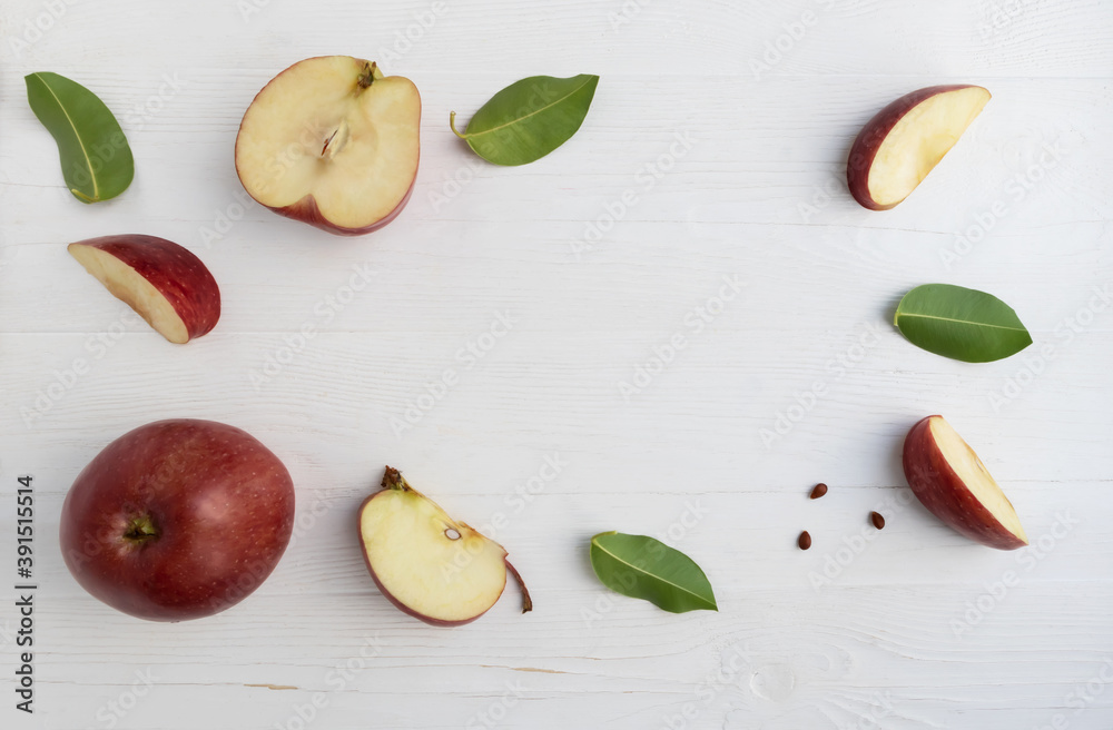 Red apples, whole and slices with leaves on a white background with space for text. Poster.