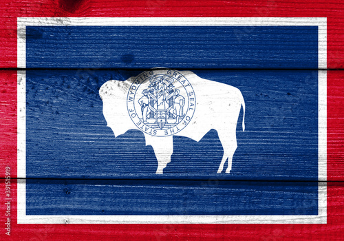 wyoming flag painted on old wood plank background. Brushed natural light knotted wooden board texture. Wooden texture background flag of wyoming