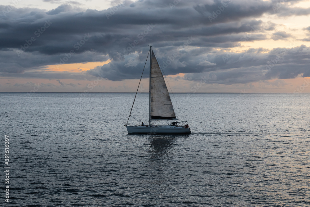 A sailboat with a sunset

