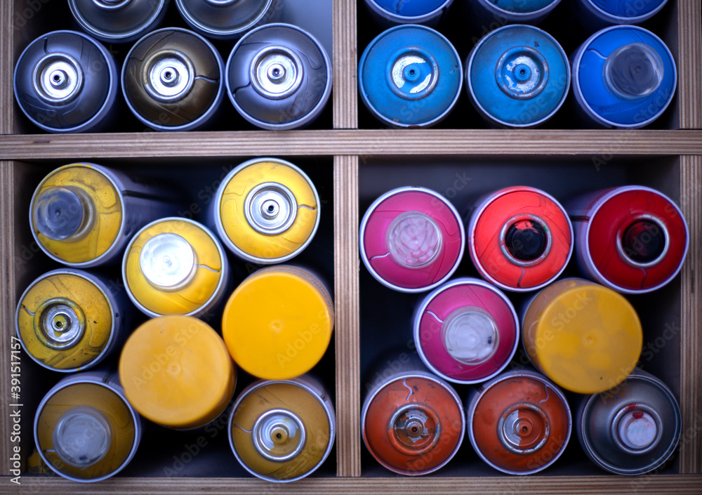 cans of paint are stacked on a shelf. Spray paint dispenser in