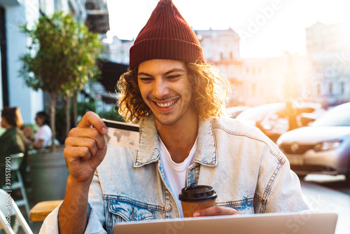 Smiling young man holding credit card