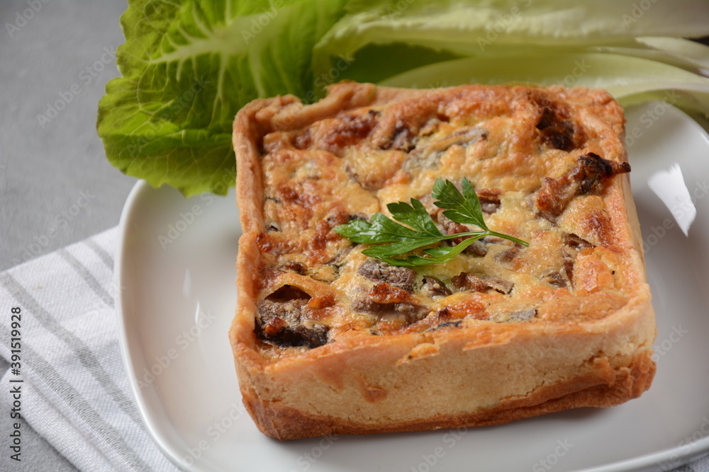 Homemade quiche or pie with  broccoli, seasonings, champignons and cheese on a gray background.