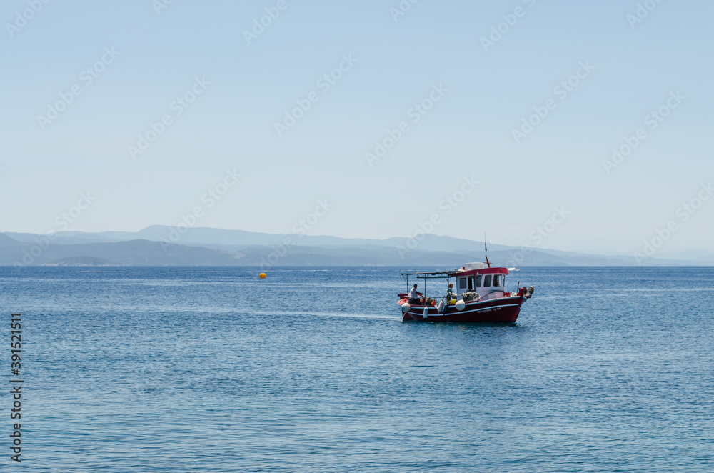 Lihada island, Greece - June 28. 2020: A boat on the sea near the island of Lihada, Greece  