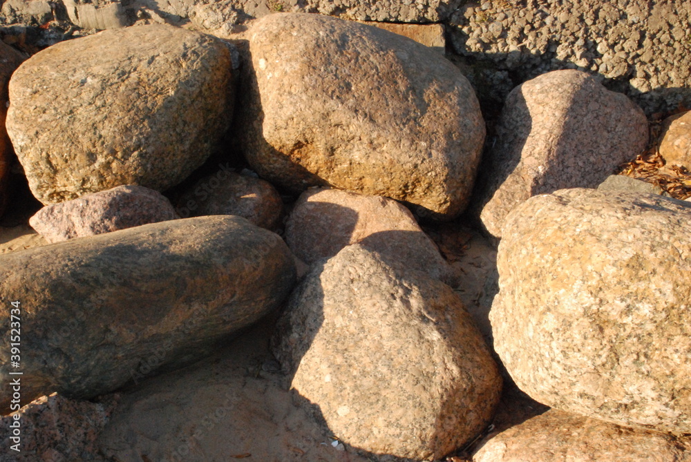 Stones on the shore against the wall.
Large stones lie close to each other against the wall on the shore of the Gulf of Finland. The setting sun illuminates the stones. The stones cast shadows on each Stones on the shore against the wall.
Large stones lie close to each other against the wall on the shore of the Gulf of Finland. The setting sun illuminates the stones. The stones cast shadows on each