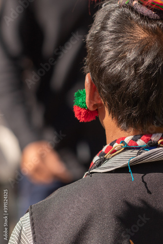 Selective focus Abstract Portrait of a young Naga tribesman dressed in his tribal attire wearing a colorful traditional earring at Kisama Nagaland India on 4 December 2016