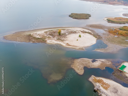 Scenic aerial drone birds eye view of swallow sand river or lake shore due to drought and water pond reservoir dam draining. Natural disaster of arid, warmand dry climate change