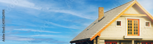 modern log cabin against blue sky. banner copy space