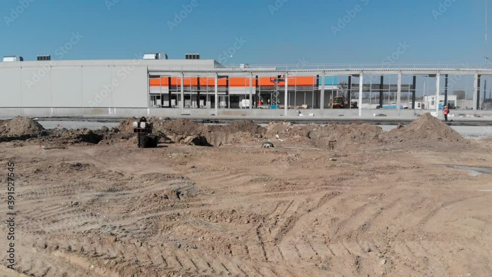 Buildings of logistics center, warehouses in field near the highway, view from height, trucks near the warehouse. Buildings of logistics center, warehouses in field near the highway, view from height, trucks near the warehouse.