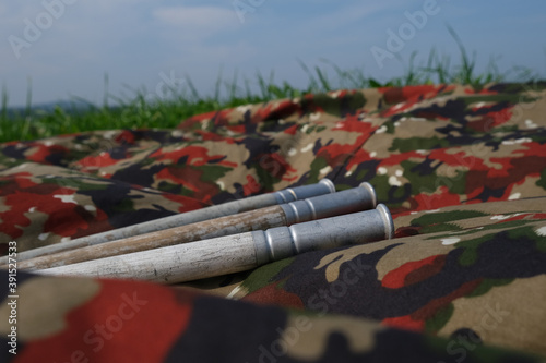 Closeup shot of a camouflage waterproof blanket with handmade old trekking sticks on it photo