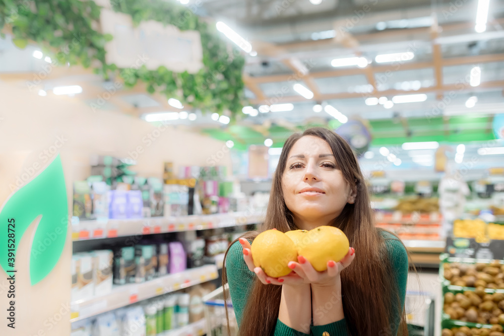 Young woman holds fragrant tangerines in her hands
Young woman holds fragrant tangerines in her hands
