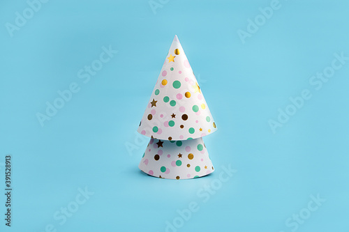 Minimalistic Christmas tree made of Colorful Hats for Party. New year simple composition. Merry Christmas and happy New Year greeting card.