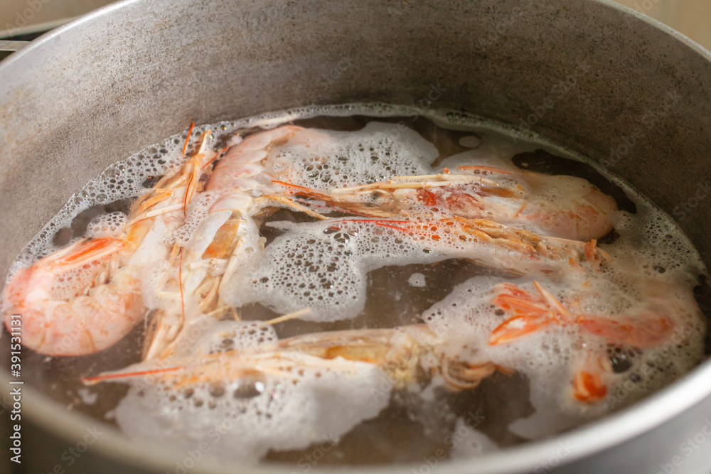 The prawns are boiled in a saucepan on a gas stove. The prawns are boiled in a saucepan on a gas stove.