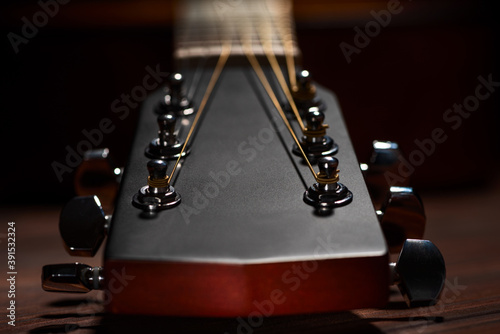 Close-up acoustic guitar on wooden background.