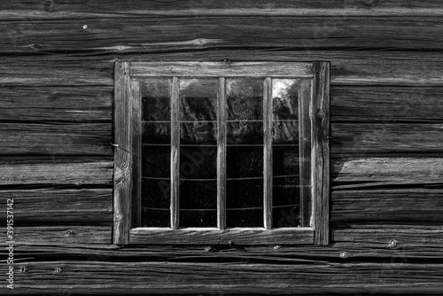 Very old window in the timbered wall of a log cabin in Sweden