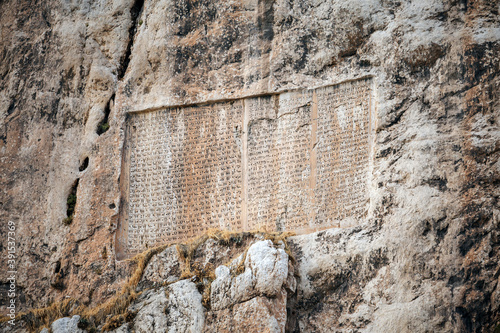 Inscription of Persian King Xerxes the Great on Van Rock, near Van Fortress, Turkey. It's written by cuneiform: 'I'm Xerxes, king of kings, by Ahuramazda favor, I ordered inscription be written, etc' photo