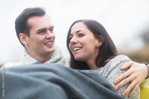 young couple outside sitting together in a garden photo