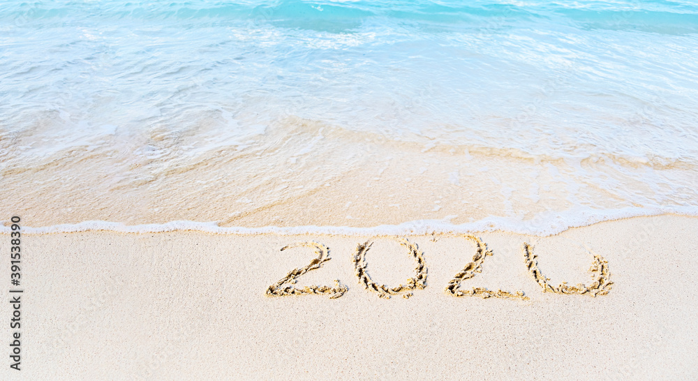 Fototapeta premium Year 2020 Written At The Sandy tropical Beach washing down with sea waves