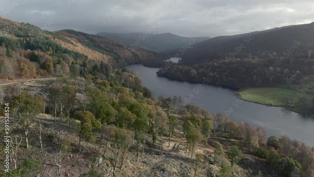 An aerial view of Loch Tummel on an autumn evening looking towards Pitlochry, Perthshire, Scotland. Rising view left to right over trees looking down the loch towards River Tummel. An aerial view of Loch Tummel on an autumn evening looking towards Pitlochry, Perthshire, Scotland. Rising view left to right over trees looking down the loch towards River Tummel.