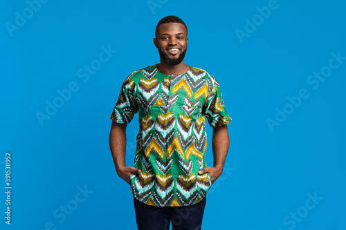 Handsome black man smiling over blue background