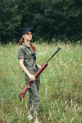 Woman Green jumpsuit black cap weapon hunting weapons 