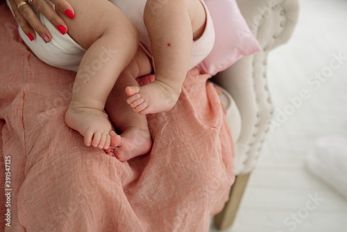 Young mother holds newborn twins in her arms and breastfeeds them	