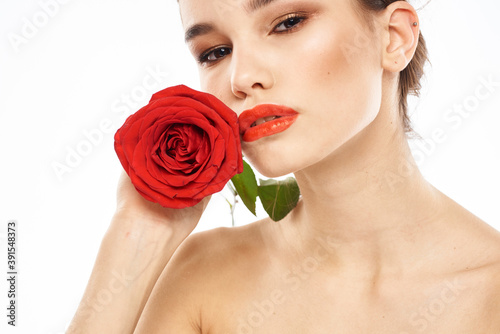 charming brunette girl with makeup on her face and a red rose in her hand