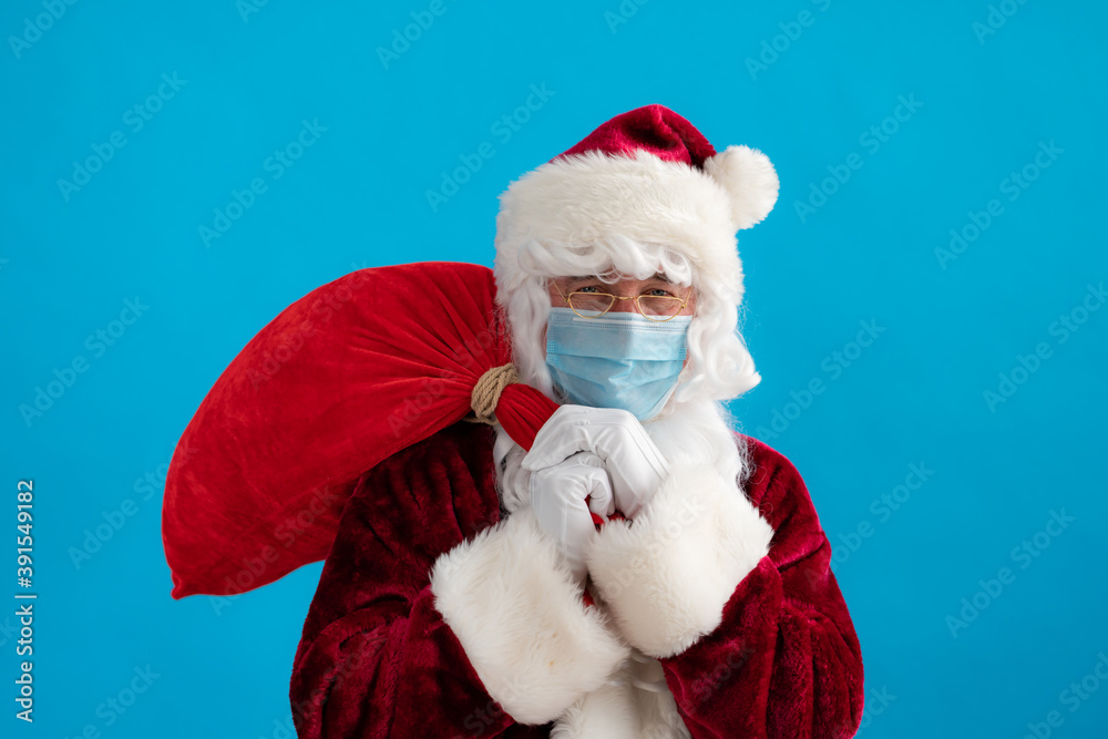 Senior man wearing Santa Claus costume and protective mask