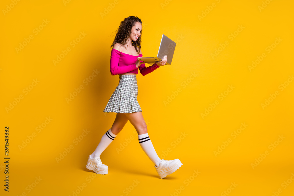 Full length body size photo of busy pretty girl keeping laptop smiling texting going fast isolated on bright yellow color background Full length body size photo of busy pretty girl keeping laptop smiling texting going fast isolated on bright yellow color background