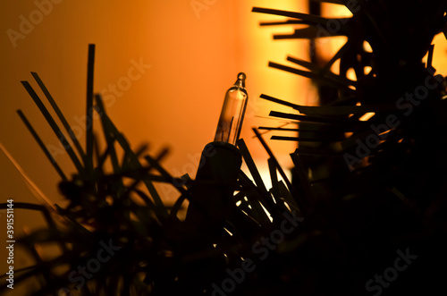 Dark Silhouette Christmas Light Bulbs against Glowing Orange Background photo