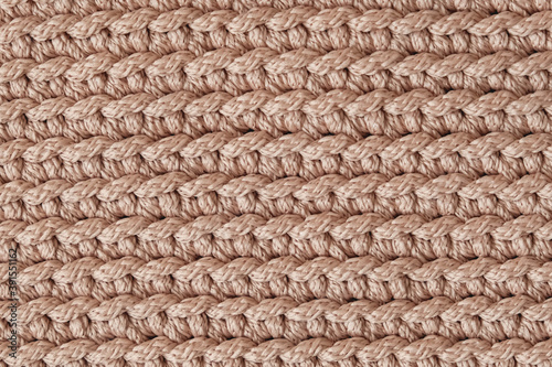 Light brown knitted fabric texture background. Top view. Copy, empty space for text