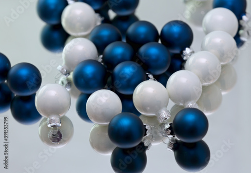 Blue and white small Christmas balls on a mirror
